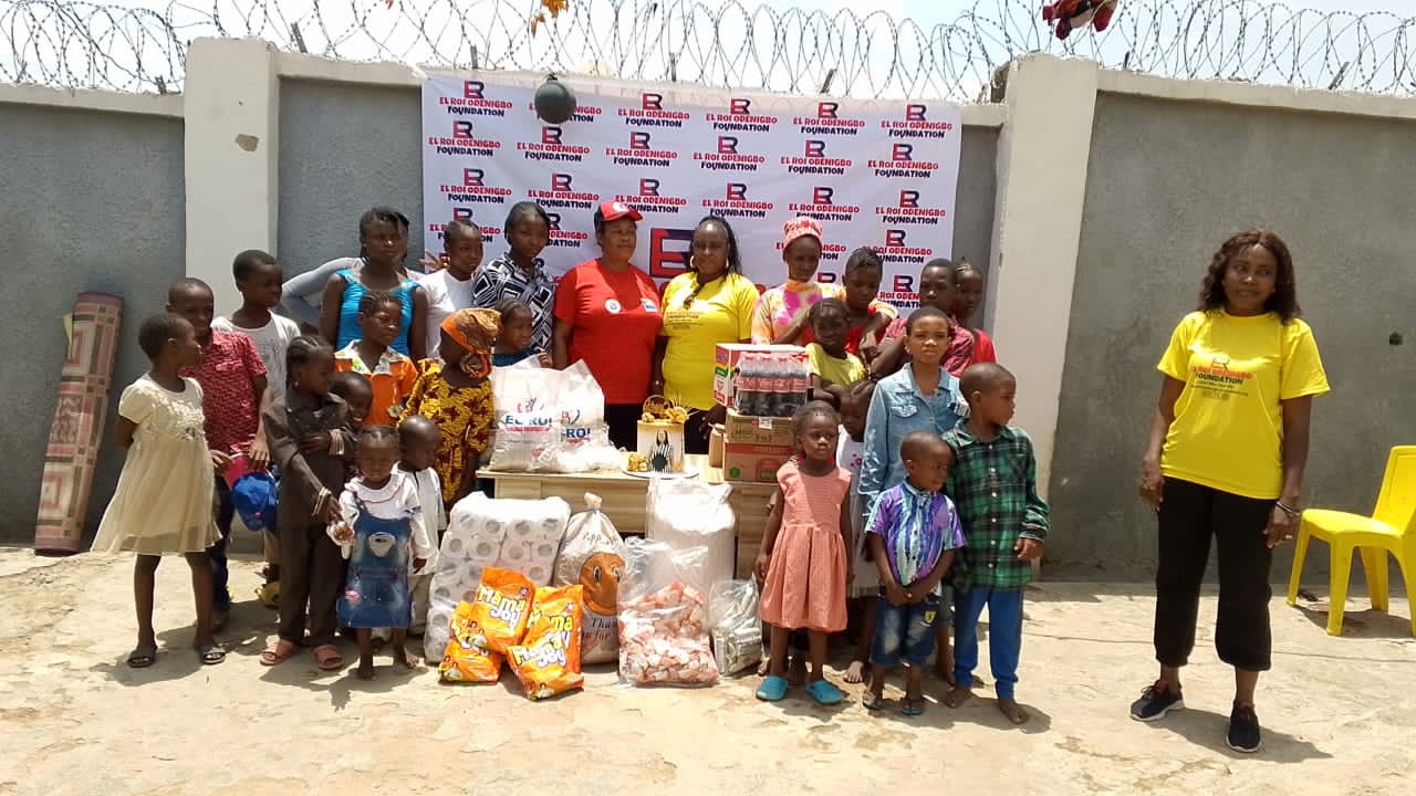 Children, families, and volunteers gathered around outreach support supplies
